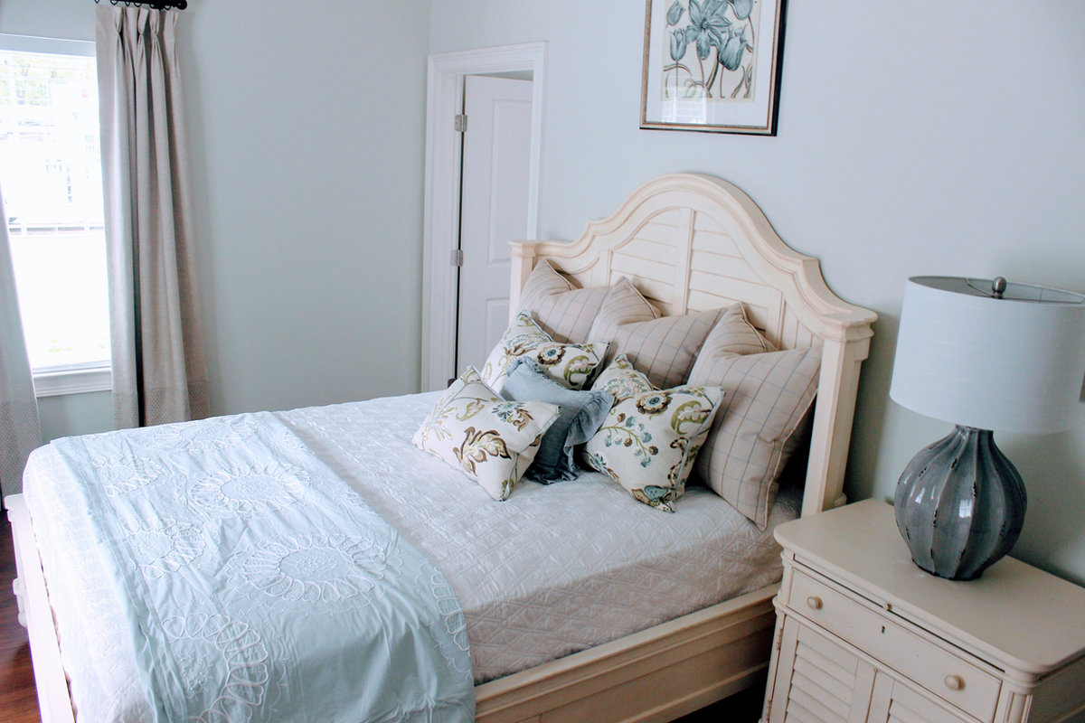 Private furnished suite with a bed and nightstand at The Orchard at Stone Creek assisted living, Hahira GA